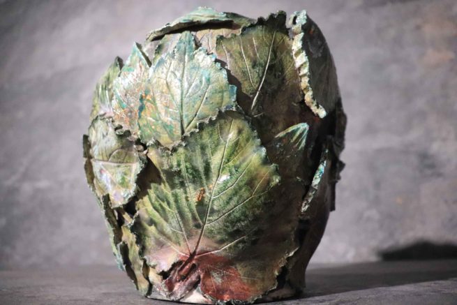 Scultura creata in ceramica artistica raku vaso con ritratto umano ricoperto di foglie