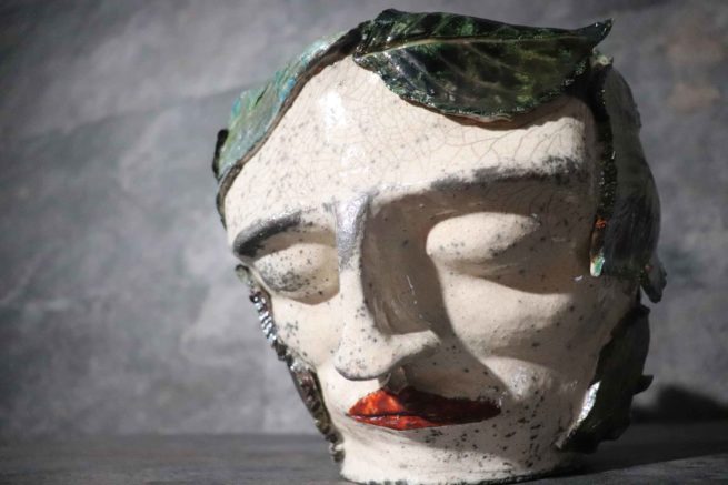 Scultura di ceramica artistica raku vaso con ritratto umano ricoperto di foglie