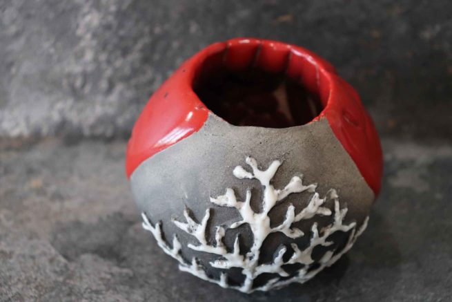 Vaso di ceramica raku rosso decorato con il motivo del corallo bianco