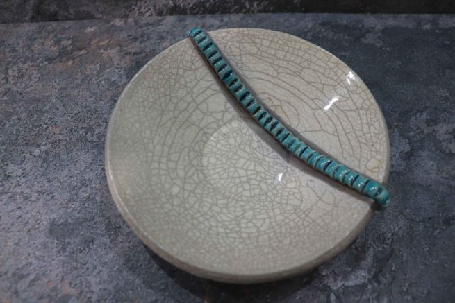 Piatto bianco in ceramica raku cavillato con decorazione turchese interamente fatto a mano.