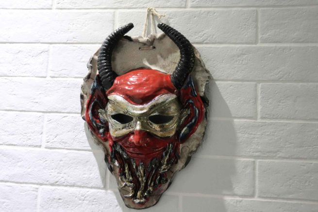 La maschera apotropaica in ceramica raku raffigura un oggetto di design per la casa, arredamento e complemento d'arredo. Realizzazione artigianale per offrire un prodotto esclusivo e raffinato.