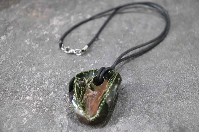 Ciondolo in ceramica Raku "Rea" di colore verde e rame. Realizzazione artigianale, interamente creata a mano con la tecnica raku. Unico e di grande effetto.