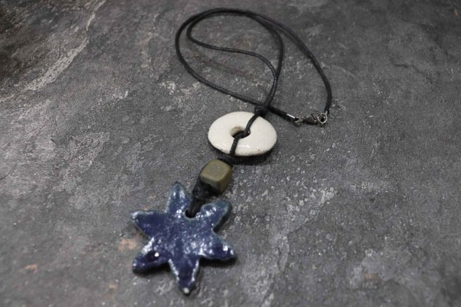 Collana in ceramica raku "Stella". La sua creazione artigianale interamente a mano con la tecnica raku rende questo gioiello unico e di grande valore artistico.