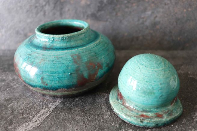 Vaso di colore turchese in ceramica artistica raku. Manufatto artigianale creato e decorato interamente a mano.